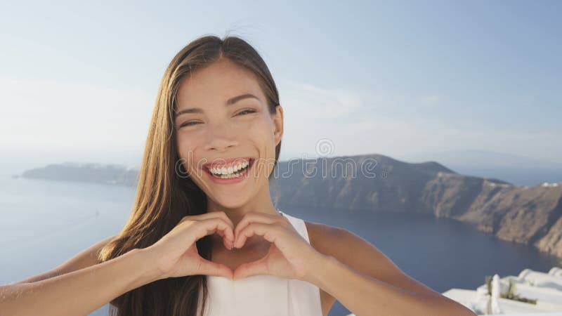 χαρούμενη γυναίκα που κάνει την καρδιά να φαίνεται αγάπη να γελάει