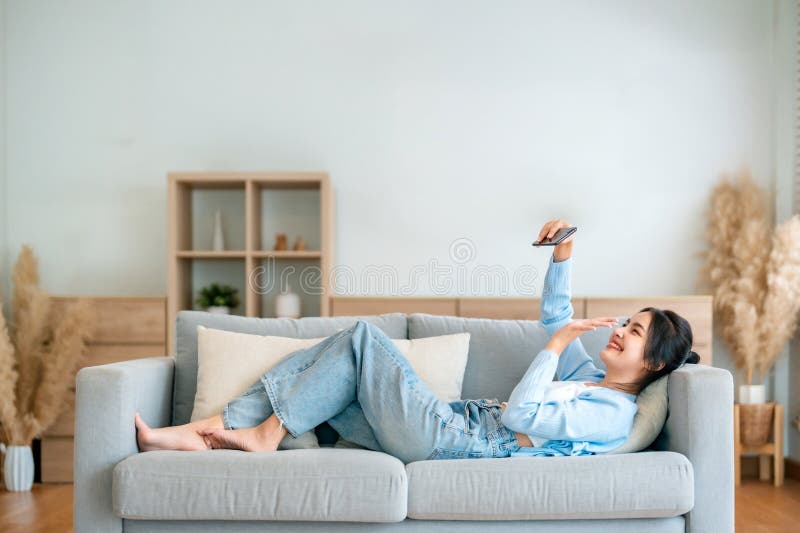 Χαρούμενη χαρούμενη θετική νεαρή Ασιάτισσα στο τηλέφωνο στο σπίτι στοκ φωτογραφία με δικαίωμα ελεύθερης χρήσης