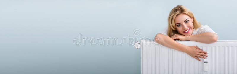χαρούμενη νεαρή γυναίκα που σκύβει στο θερμαντικό ψυγείο στοκ φωτογραφίες