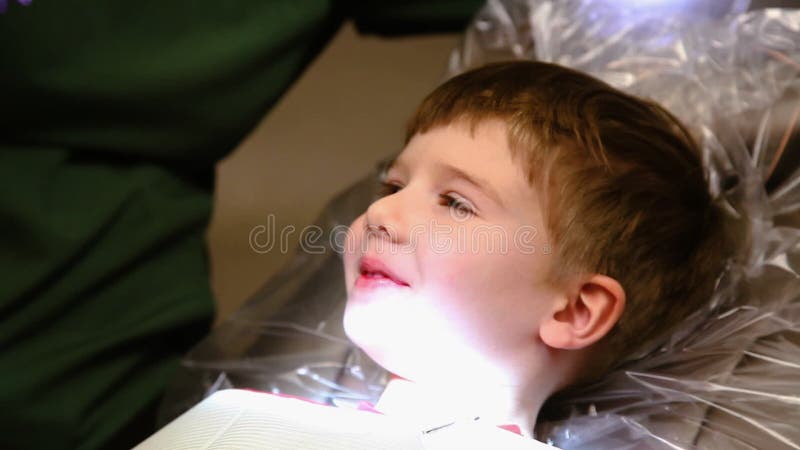 Χαρούμενο αγόρι χαμογελά ενώ καθαρίζονται τα δόντια του στον οδοντίατρο