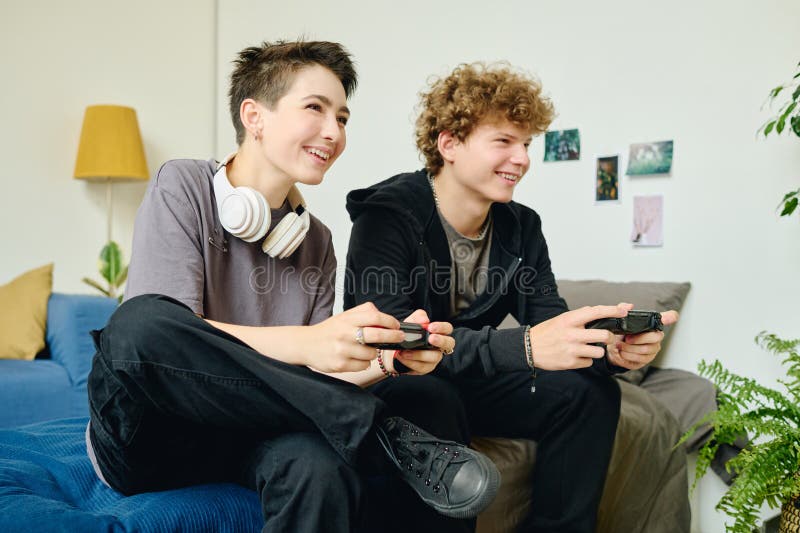 χαρούμενοι έφηβοι φίλοι ή ραντεβού με gamepads που παίζουν βιντεοπαιχνίδια στοκ φωτογραφία