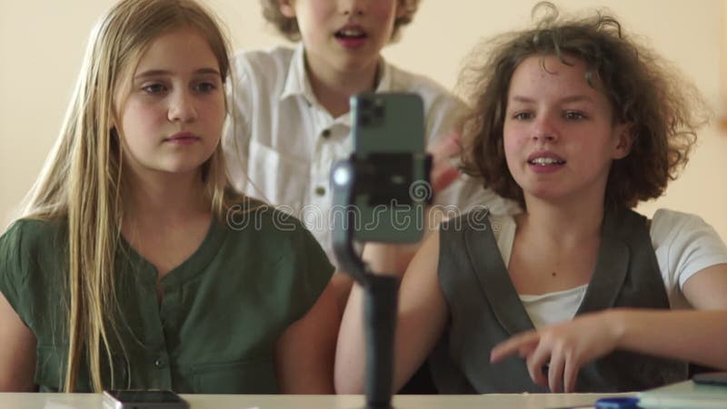 χαρούμενοι χοροί μπροστά από κορίτσια smartphone και ένα αγόρι διασκεδάζουν κινηματογραφώντας βίντεο για κοινωνικά δίκτυα βίντεο b