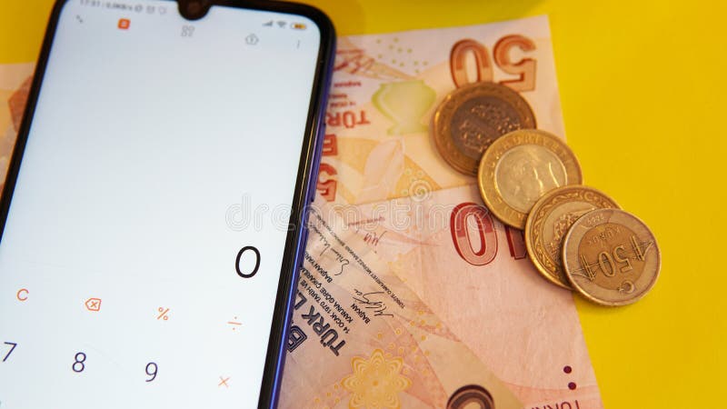 χαρτί και κέρματα σε κίτρινο φόντο με υπολογιστή ανοιχτό σε κινητό τηλέφωνο στις ηπα στις 23 απριλίου 2020.