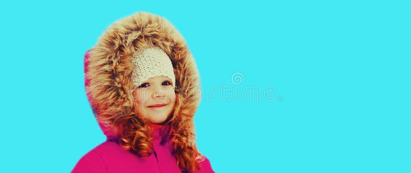 χειμερινό πορτρέτο ενός χαρούμενου χαμογελαστού μικρού κοριτσιού σε μπλε φόντο