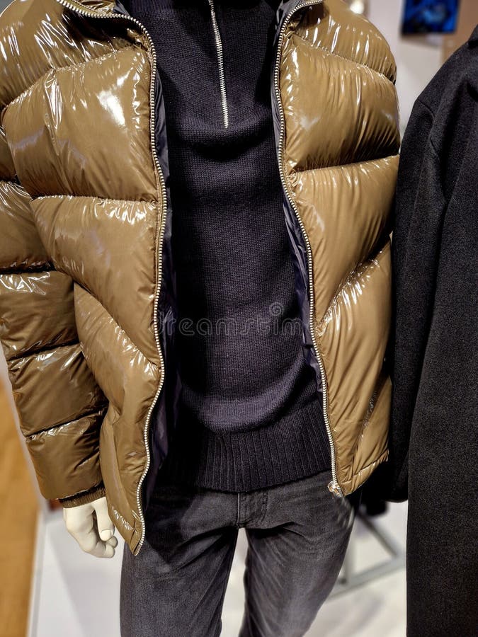 γυαλιστερά, φουσκωτά χειμωνιάτικα μπουφάν σε μια φιγούρα με έναν θάλαμο που γεμίζει με πούπουλα χήνας στοκ εικόνες