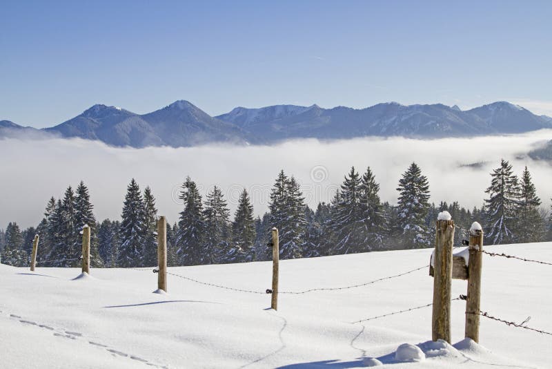 Fog in the valley and sun on the mountains - Winter idyll in the Isarwinkel near Bad Toelz. Fog in the valley and sun on the mountains - Winter idyll in the Isarwinkel near Bad Toelz