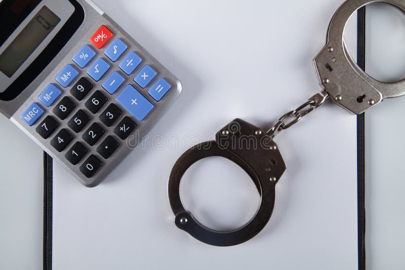 χειροπέδες σε κενό φύλλο χαρτί και αριθμομηχανή στο τραπέζι στοκ φωτογραφίες με δικαίωμα ελεύθερης χρήσης