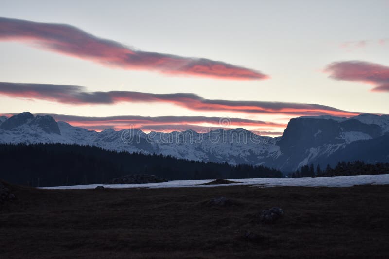 Χιονισμένο ηλιοβασίλεμα βουνών Durmitor με τον ουρανό κοκκινίσματος στοκ εικόνες με δικαίωμα ελεύθερης χρήσης Χιονισμένο ηλιοβασίλεμα βουνών Durmitor με τον ουρανό κοκκινίσματος στοκ εικόνες με δικαίωμα ελεύθερης χρήσης