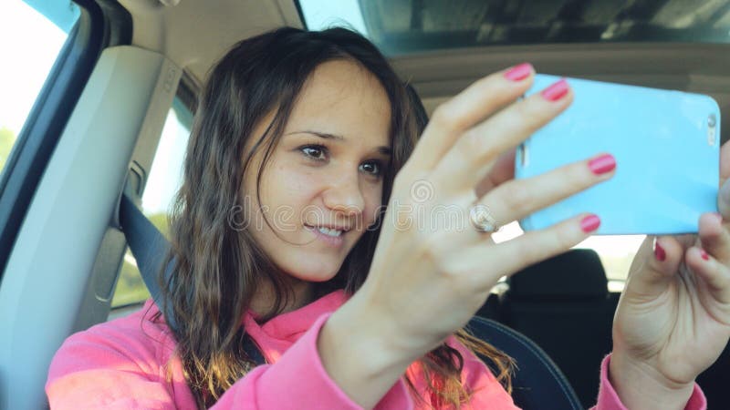 Χορός γυναικών χαμόγελου ο νέος και λήψη selfie απεικονίζει με την έξυπνη τηλεφωνική κάμερα στο αυτοκίνητο στοκ εικόνες Χορός γυναικών χαμόγελου ο νέος και λήψη selfie απεικονίζει με την έξυπνη τηλεφωνική κάμερα στο αυτοκίνητο στοκ εικόνες