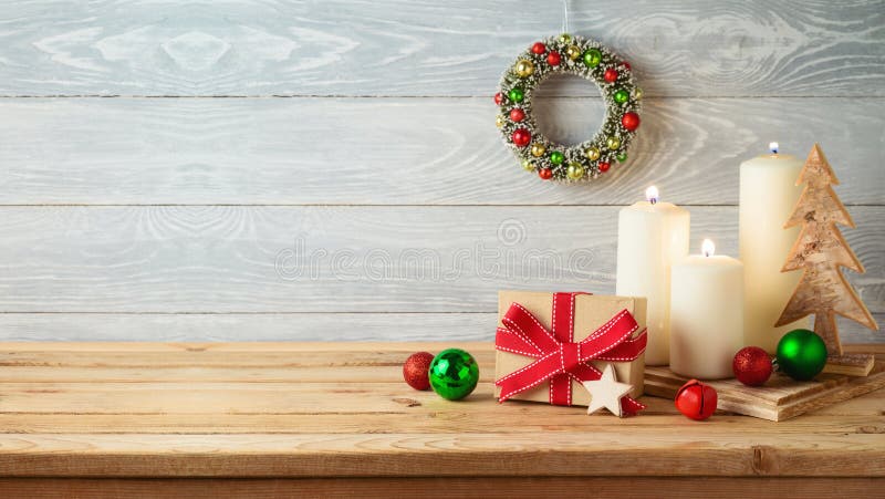 Χριστουγεννιάτικο φόντο με κουτί δώρων, στολίδια και διακόσμηση κεριών σε ξύλινο τραπέζι Κάρτα χειμερινού χαιρετισμού
