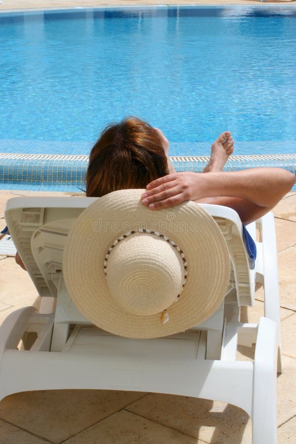 Woman relaxes by the pool. Woman relaxes by the pool