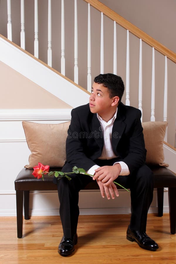 A young man watches and waits for his date to be ready. A young man watches and waits for his date to be ready.