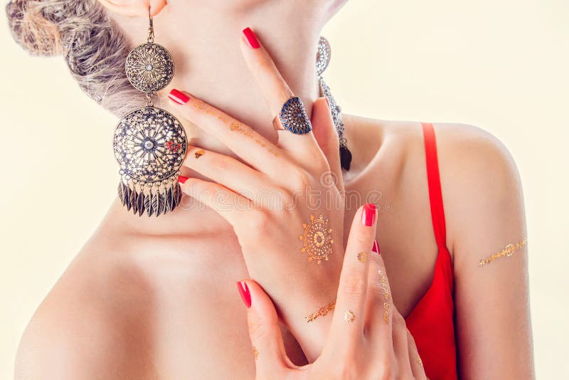 Χρυσή δερματοστιξία mehendi στο woman& x27 χέρια του s με το κόκκινο μανικιούρ στοκ φωτογραφίες με δικαίωμα ελεύθερης χρήσης
