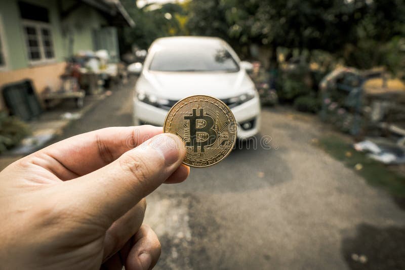 Χρυσό Bitcoin υπό εξέταση πέρα από το άσπρο αυτοκίνητο στοκ εικόνες Χρυσό Bitcoin υπό εξέταση πέρα από το άσπρο αυτοκίνητο στοκ εικόνες