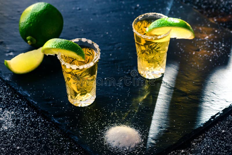 Χρυσό μεξικάνικο tequila με τον ασβέστη και το άλας στοκ εικόνα Χρυσό μεξικάνικο tequila με τον ασβέστη και το άλας στοκ εικόνα