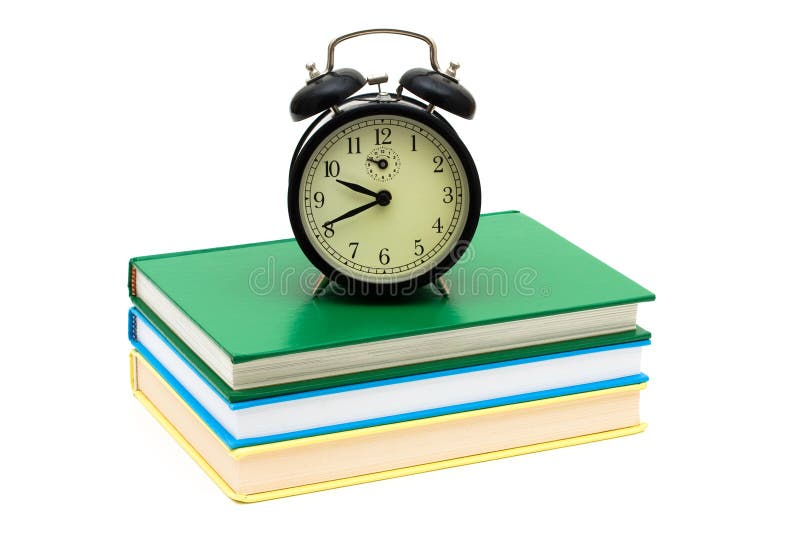 An old fashioned clock on a books isolated on a white background, Time to study. An old fashioned clock on a books isolated on a white background, Time to study