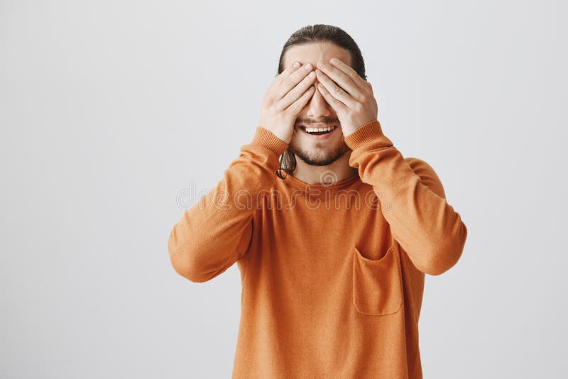 Χρόνος να παραληφθεί η έκπληξη Πορτρέτο της γοητείας του ανυπόμονου ατόμου στο πορτοκαλί πουλόβερ που καλύπτει το όραμα με τους φ στοκ εικόνες Χρόνος να παραληφθεί η έκπληξη Πορτρέτο της γοητείας του ανυπόμονου ατόμου στο πορτοκαλί πουλόβερ που καλύπτει το όραμα με τους φ στοκ εικόνες