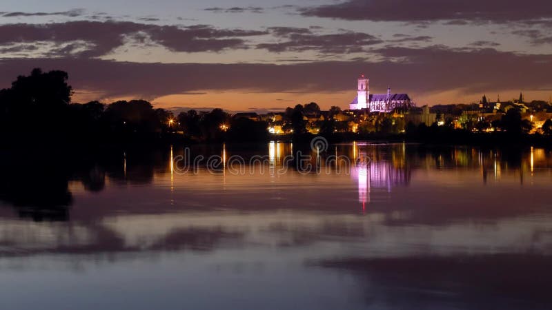 Χρόνος-σφάλμα καθεδρικών ναών Nevers στο ηλιοβασίλεμα πέρα από τον ποταμό της Loire