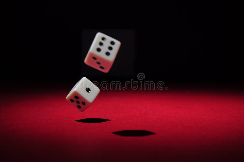 Two dices falling on a red surface. The light in the scene is spot like. Two dices falling on a red surface. The light in the scene is spot like.