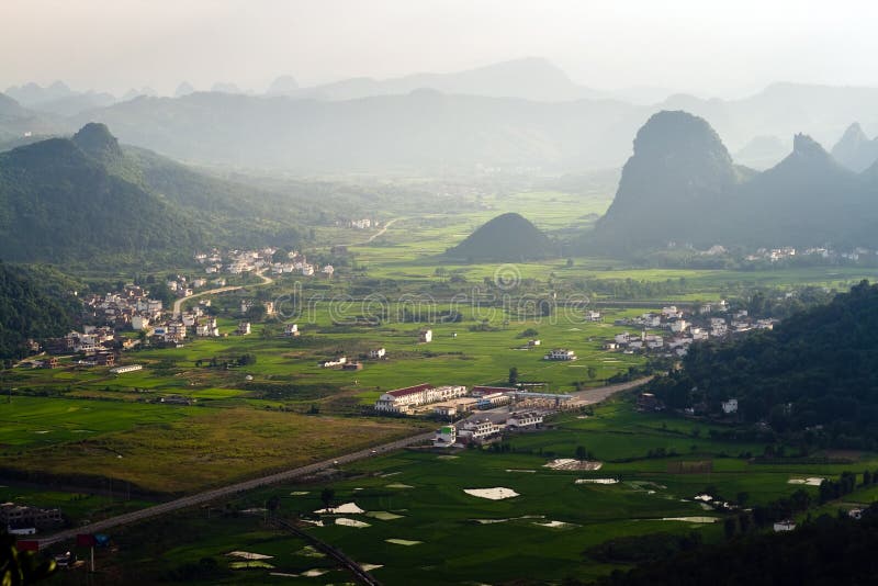 Χωριό Guilin στο ηλιοβασίλεμα από το βουνό Hill φεγγαριών Yangshuo στοκ φωτογραφία με δικαίωμα ελεύθερης χρήσης Χωριό Guilin στο ηλιοβασίλεμα από το βουνό Hill φεγγαριών Yangshuo στοκ φωτογραφία με δικαίωμα ελεύθερης χρήσης