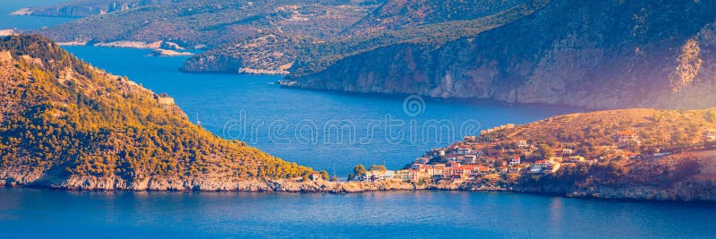 Χωριό Άσος στην Κεφαλονία Ελλάδα. Ο Τυρκουάζ έγχρωμος κόλπος στη Μεσόγειο θάλασσα με όμορφα πολύχρωμα σπίτια στο χωριό Άσος στο στοκ εικόνες με δικαίωμα ελεύθερης χρήσης