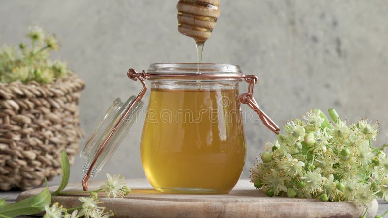 χύτευση μελιού από μία σταγόνα σε ένα γυάλινο βάζο με φρέσκα λινά άνθη την άνοιξη φιλμ μικρού μήκους