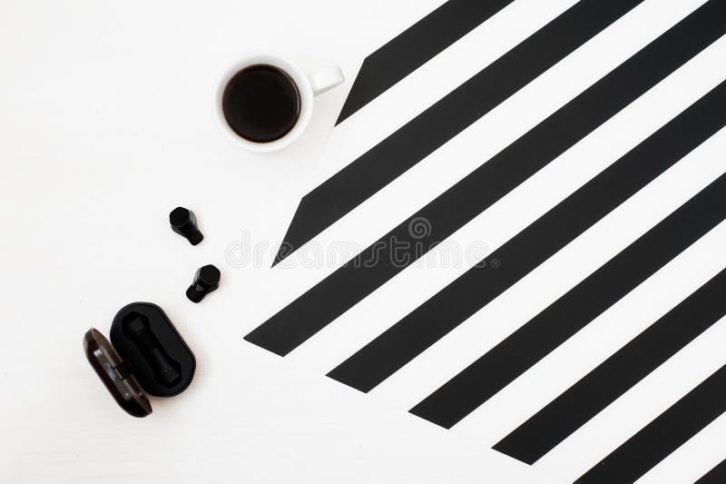 Χώρος εργασίας Minimalistic με το φλιτζάνι του καφέ, ασύρματα ακουστικά στο ριγωτό γραπτό υπόβαθρο Επίπεδος βάλτε τη τοπ άποψη ύφ στοκ φωτογραφία με δικαίωμα ελεύθερης χρήσης Χώρος εργασίας Minimalistic με το φλιτζάνι του καφέ, ασύρματα ακουστικά στο ριγωτό γραπτό υπόβαθρο Επίπεδος βάλτε τη τοπ άποψη ύφ στοκ φωτογραφία με δικαίωμα ελεύθερης χρήσης