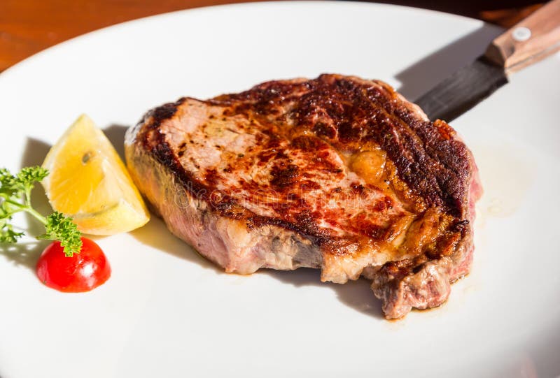 Ψημένη στη σχάρα ribeye μπριζόλα με το μαχαίρι στο εστιατόριο στοκ εικόνες Ψημένη στη σχάρα ribeye μπριζόλα με το μαχαίρι στο εστιατόριο στοκ εικόνες