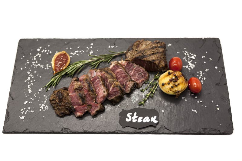 Ψημένη στη σχάρα striploin μπριζόλα ένα στις ψημένες πατάτες πετρών πιάτο και τη σάλτσα σχαρών στοκ εικόνες με δικαίωμα ελεύθερης χρήσης