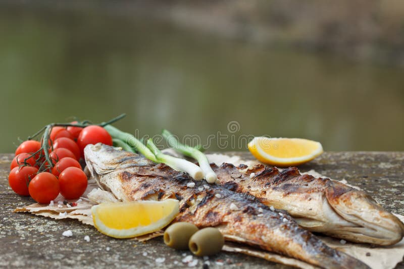 Ψημένο στη σχάρα seabass με την ντομάτα, το λεμόνι και το δεντρολίβανο στοκ εικόνες με δικαίωμα ελεύθερης χρήσης Ψημένο στη σχάρα seabass με την ντομάτα, το λεμόνι και το δεντρολίβανο στοκ εικόνες με δικαίωμα ελεύθερης χρήσης