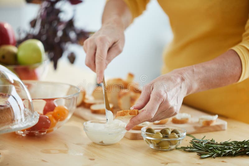 Ψωμί Buttering με το μαχαίρι στοκ φωτογραφία Ψωμί Buttering με το μαχαίρι στοκ φωτογραφία