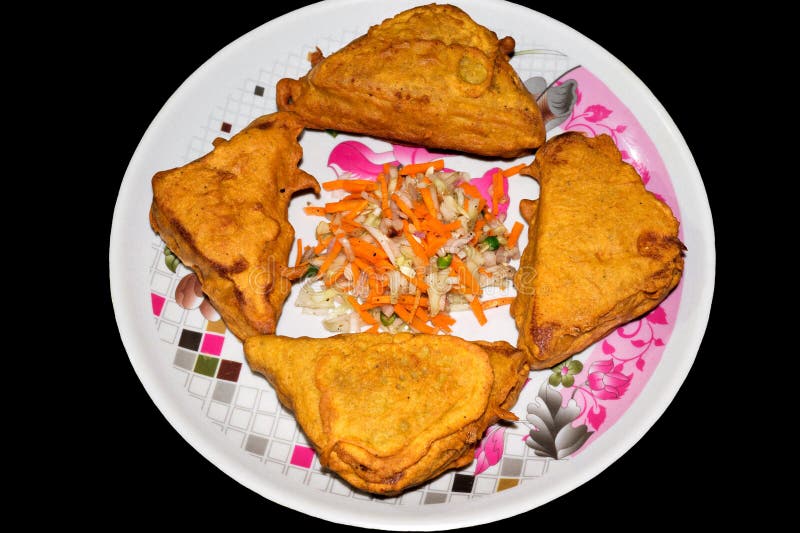 Ψωμί Pakora μορφής τριγώνων σε ένα πιάτο στο μαύρο υπόβαθρο με την τεμαχισμένη σαλάτα στοκ φωτογραφία με δικαίωμα ελεύθερης χρήσης Ψωμί Pakora μορφής τριγώνων σε ένα πιάτο στο μαύρο υπόβαθρο με την τεμαχισμένη σαλάτα στοκ φωτογραφία με δικαίωμα ελεύθερης χρήσης