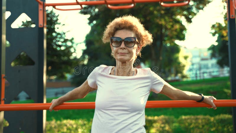 ωριμότητα ευρωπαϊκή γυναίκα απολαμβάνει την άσκηση σε εξωτερικό χώρο το καλοκαίρι. εστιάζει στο να τεντώνει και να ζεσταίνει την π απόθεμα βίντεο