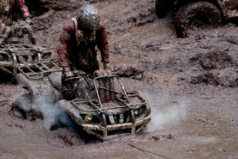 A view of two all-terrain vehicles driving through mud as part of an off road endurance race. A view of two all-terrain vehicles driving through mud as part of an off road endurance race.