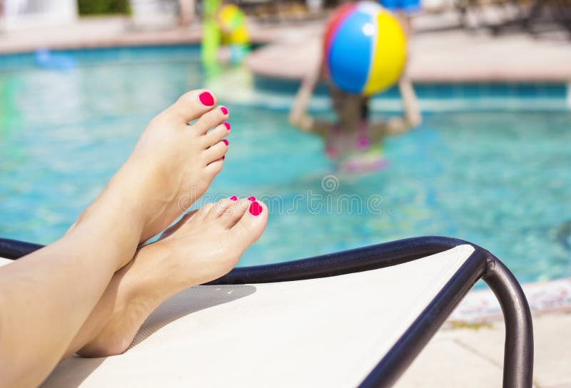 Beautiful female feet relaxing by the swimming pool. Great pedicure photo. Beautiful female feet relaxing by the swimming pool. Great pedicure photo.