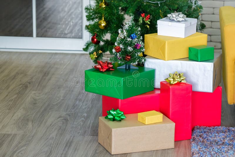 Όμορφα χριστουγεννιάτικα κουτιά δώρων στο πάτωμα κοντά στο δέντρο στοκ εικόνες Όμορφα χριστουγεννιάτικα κουτιά δώρων στο πάτωμα κοντά στο δέντρο στοκ εικόνες