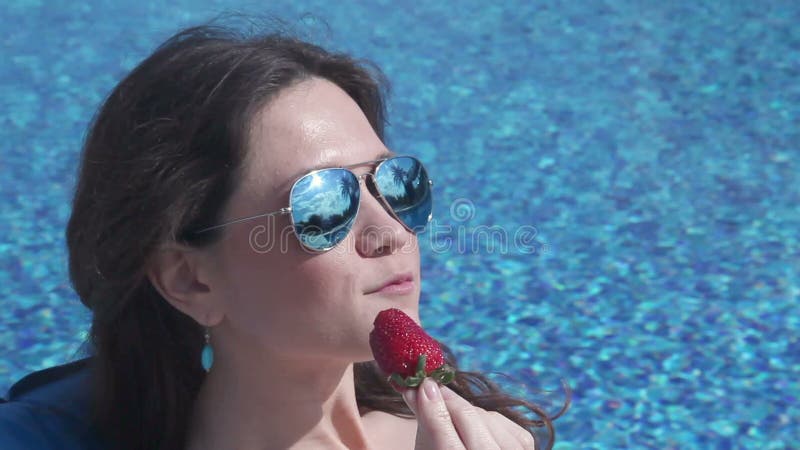 Όμορφη γυναίκα brunette που τρώει τη γλυκιά φράουλα, ευτυχές πρόσωπο φιλμ μικρού μήκους