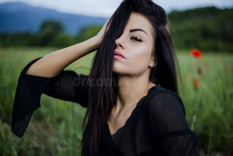 Όμορφη γυναίκα brunette στα γυαλιά ηλίου και τα μοντέρνα ενδύματα που κάθεται μεταξύ στις κόκκινες παπαρούνες στοκ φωτογραφία με δικαίωμα ελεύθερης χρήσης Όμορφη γυναίκα brunette στα γυαλιά ηλίου και τα μοντέρνα ενδύματα που κάθεται μεταξύ στις κόκκινες παπαρούνες στοκ φωτογραφία με δικαίωμα ελεύθερης χρήσης