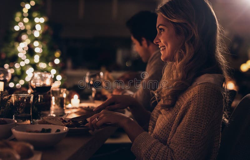 Όμορφη γυναίκα που έχει το γεύμα Χριστουγέννων με την οικογένεια στοκ φωτογραφίες Όμορφη γυναίκα που έχει το γεύμα Χριστουγέννων με την οικογένεια στοκ φωτογραφίες