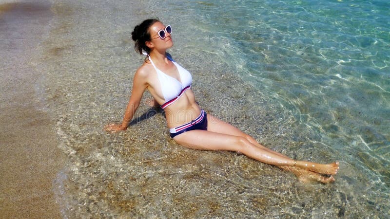 όμορφη γυναίκα που παίρνει χρώμα στα κύματα. ελκυστική κοπέλα με γυαλιά ηλίου για διακοπές στοκ φωτογραφία με δικαίωμα ελεύθερης χρήσης