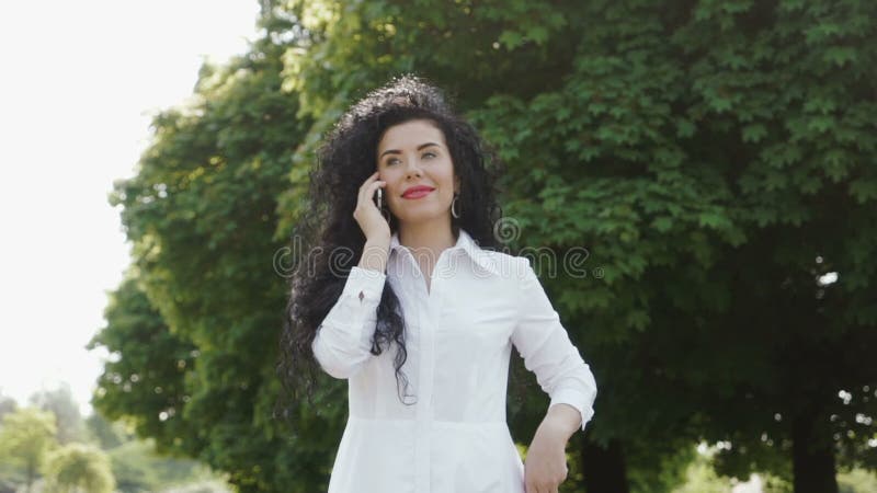 Όμορφη κλήση brunette στο φίλο τηλεφωνικώς απόθεμα βίντεο