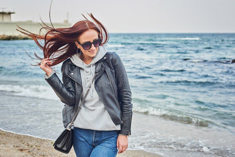 Όμορφη νέα redhead γυναίκα που μένει στην παραλία κοντά στον ωκεανό στοκ φωτογραφία με δικαίωμα ελεύθερης χρήσης Όμορφη νέα redhead γυναίκα που μένει στην παραλία κοντά στον ωκεανό στοκ φωτογραφία με δικαίωμα ελεύθερης χρήσης