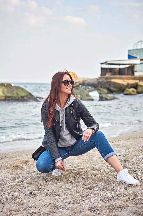 Όμορφη νέα redhead τοποθέτηση γυναικών στην παραλία κοντά στον ωκεανό στοκ φωτογραφίες με δικαίωμα ελεύθερης χρήσης Όμορφη νέα redhead τοποθέτηση γυναικών στην παραλία κοντά στον ωκεανό στοκ φωτογραφίες με δικαίωμα ελεύθερης χρήσης