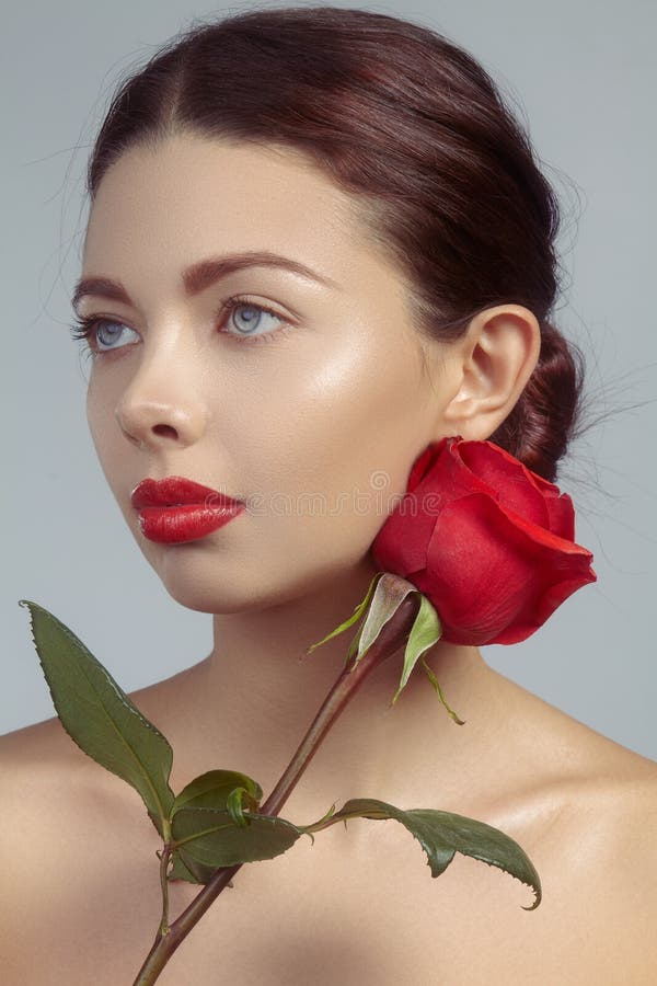 Όμορφη νέα γυναίκα κινηματογραφήσεων σε πρώτο πλάνο με τα φωτεινά lipgloss makeup Τέλειο καθαρό δέρμα, προκλητική κόκκινη χειλική