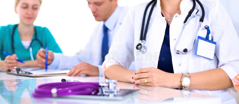 Όμορφη νέα συνεδρίαση γιατρών χαμόγελου θηλυκή στο γραφείο στοκ εικόνες Όμορφη νέα συνεδρίαση γιατρών χαμόγελου θηλυκή στο γραφείο στοκ εικόνες
