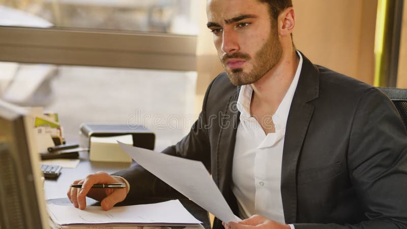 Όμορφη νέα συνεδρίαση επιχειρηματιών στο γραφείο στην αρχή στοκ εικόνα Όμορφη νέα συνεδρίαση επιχειρηματιών στο γραφείο στην αρχή στοκ εικόνα