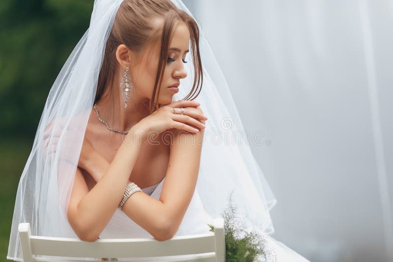 όμορφη νύφη με ένα υπέροχο νυφικό που ποζάρει ανάμεσα στο πράσινο στο δρόμο. σύλληψη νύφης για διαφήμιση στοκ φωτογραφίες