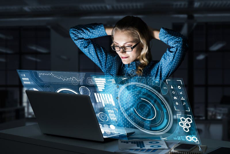Όμορφη ξανθή εργασία στο lap-top και infographs από την οθόνη Μικτά μέσα στοκ εικόνα Όμορφη ξανθή εργασία στο lap-top και infographs από την οθόνη Μικτά μέσα στοκ εικόνα