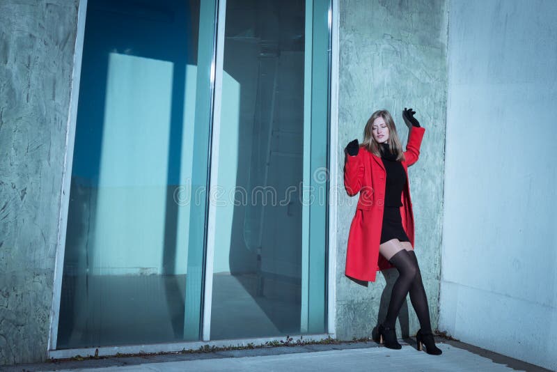 Όμορφη τοποθέτηση κοριτσιών με το κόκκινο παλτό