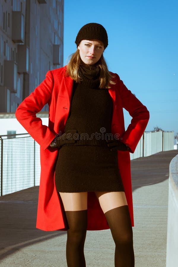 Όμορφη τοποθέτηση κοριτσιών με το κόκκινο παλτό
